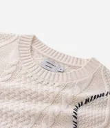 Suéter de cuello redondo y manga larga, confeccionado en tejido de punto con textura de ochos y detalles lineales en contraste. Presenta puños y ruedo acanalados.
