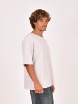 Remera blanca de manga corta y cuello redondo, corte holgado.