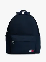 Mochila de diseño redondeado color azul marino, con asa superior, correas ajustables y acolchadas. Presenta un compartimento principal con cierre, bolsillo exterior con cremallera y parche con el logo de Tommy Jeans en la parte delantera.