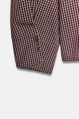 Camisa de manga larga con cuello solapa y diseño de cuadros pequeños. Presenta mangas con pliegues y cierre frontal con botones ocultos.