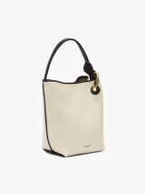 Bolso de hombro tipo bucket color crema, con detalles en cuero negro y herrajes dorados.