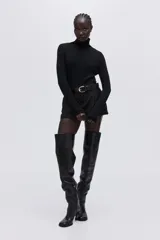 Top de manga larga confeccionado en punto fino, con diseño de corte ajustado y cuello alto.