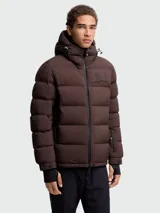 Campera puffer de esquí Moncler Grenoble modelo Isorno, color marrón oscuro, con capucha ajustable, cierre frontal, bolsillos laterales y puños con aberturas para pulgares.