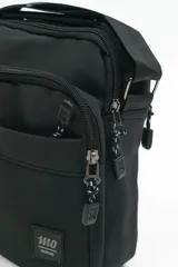 Morral de diseño compacto en color negro, con múltiples compartimentos con cierre, correa ajustable y manija superior. Presenta un parche con logo en la parte frontal.