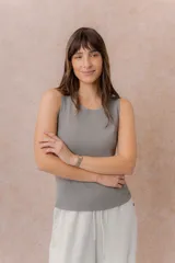 Musculosa de tejido fino con textura acanalada, color blanco, escote redondo y hombros anchos.