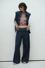 Pantalón de jean azul oscuro de pierna ancha con costuras marcadas al frente, tiro medio y calce relajado.