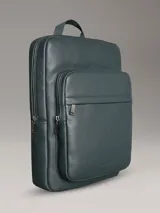 Mochila Calvin Klein color verde oscuro, de cuero sintético con textura micro pebble. Tiene un bolsillo frontal con cierre, asa de mano y correas acolchadas ajustables. Interior con funda acolchada para laptop, bolsillo con cierre y portabolígrafos.