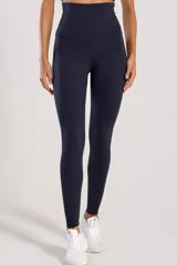 Calza deportiva larga de color negro, de tiro alto y diseño modelador, confeccionada con tejido de alta elasticidad y tacto suave.