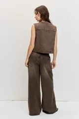 Pantalón de denim estilo wide leg color marrón gastado, con apliques de tachas metálicas o strass distribuidos por toda la prenda y tiro medio.