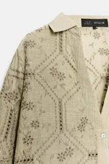 Camisa de cuello solapa con escote en V, manga larga y cierre frontal con botones. Presenta un diseño con bordados perforados en todo la prenda.