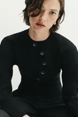 Chaqueta de punto de manga larga con cuello redondo y cierre frontal asimétrico con botones.