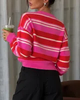 Sweater de tejido de punto con diseño de rayas horizontales en tonos fucsia, rojo y blanco, con escote en V y cuello tipo polo.