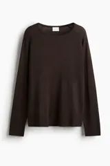Buzo de punto fino color marrón oscuro, de corte holgado con escote redondo y mangas raglán. Presenta puños y bajo acanalados.