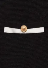 Pantalon de punto fino color negro, de corte recto y tiro medio. Presenta cintura elástica, dos bolsillos delanteros con ribete en contraste color blanco y botones decorativos dorados.