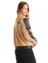 Campera de corderito sintético color beige con paneles y detalles en cuero sintético negro. Presenta cuello alto con tira y hebilla metálica, cierre frontal metálico y mangas largas con paneles de cuero sintético.