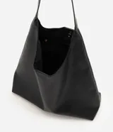 Cartera hobo grande de poliuretano color verde militar, con diseño slouchy, base estructurada y una única asa larga para llevar al hombro. Cuenta con cierre de botón a presión y amplio compartimento interior.