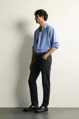 Jeans slim fit de tiro medio, color celeste claro con efecto lavado. Confeccionados en tejido elástico, cuentan con diseño de cinco bolsillos y cierre frontal con cremallera y botón metálico.