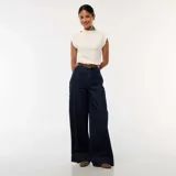 Jean de corte wide leg en color azul oscuro, con diseño de cinco bolsillos y costuras verticales decorativas en el frente. Presenta un tiro alto con cierre de botón y cremallera.