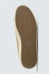 Zapatilla de cordones para hombre, fabricada en piel con acabado serraje (gamuza) color beige claro. Presenta detalles de pespuntes y una suela gruesa de goma a contraste en color crema.