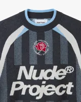 Suéter de punto con diseño inspirado en camisetas de fútbol retro. Presenta un patrón de rayas verticales en tonos gris oscuro, gris claro y celeste, con el logo de la marca en gran tamaño en el frente y un detalle de rosa bordada en el pecho. Posee cuello redondo y puños acanalados.