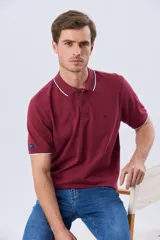 Remera polo de piqué azul marino, con cuello y puños de mangas cortas con ribete blanco en contraste, cierre frontal de dos botones y pequeño logo bordado en el pecho.