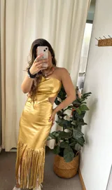 Vestido dorado de fiesta, strapless, con abertura en la cintura y falda midi con flecos.