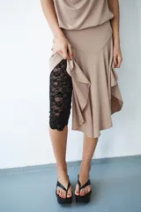 Vestido midi de color beige con cuello halter y escote drapeado. Presenta un diseño con espalda descubierta y falda con bajo asimétrico.