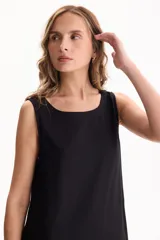 Vestido largo negro de lino, sin mangas, con escote redondo y diseño fluido con volados escalonados en la falda.