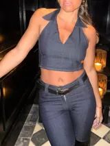 Top corto de jean azul oscuro con escote en V profundo y cuello tipo camisa. Diseño sin mangas, ajustado al cuerpo.