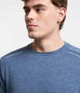 Remera deportiva masculina de manga corta con cuello redondo, confeccionada en tejido técnico con tecnología Dry para mayor transpirabilidad. Presenta detalles reflectantes en los hombros y un diseño liso en color verde melange.