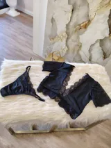 Conjunto de lencería compuesto por un top de encaje y microtul con escote profundo y una tanga regulable a juego. El top presenta mangas cortas de encaje y detalles de puntilla, mientras que la tanga combina microtul y encaje con forro de algodón.