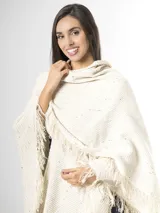 Ruana off white de tejido texturado con detalles sutiles de hilos multicolor y terminación de flecos en los bordes.