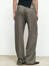 Pantalón gris de vestir, corte recto y holgado, con pinzas delanteras y bolsillos laterales.