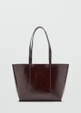 Bolso tipo shopper de diseño estructurado en color bordó con acabado brillante y efecto arrugado. Cuenta con doble asa larga para llevar al hombro y costuras verticales decorativas en el frente.
