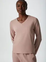 Pijama de dos piezas color rosa, compuesto por una remera de mangas largas con cuello en V y un pantalón largo de corte recto.