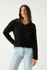 Sweater color beige de tejido de punto acanalado, con escote en V y corte ligeramente holgado.