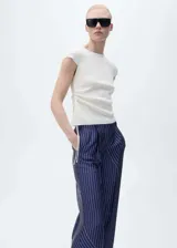 Pantalon de corte recto y diseño fluido con acabado satinado. Presenta un estampado de rayas verticales con detalles de franjas horizontales en el ruedo, cierre frontal con botón y cremallera, pinzas en la cintura y bolsillos laterales.