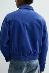 Sobrecamisa regular fit de Zara, confeccionada en pana de algodón color azul con efecto lavado. Cuenta con cuello solapa, manga larga con puño y botón a presión, bolsillos frontales de plastrón con solapa y cierre de cremallera.