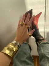 Brazalete rígido de diseño ancho y superficie lisa con acabado brillante en tono dorado.