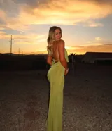 Conjunto de dos piezas color verde oliva, compuesto por un top con escote profundo y diseño cruzado, y una falda midi ajustada de tiro alto.