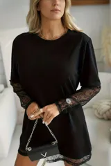 Vestido remerón negro de manga larga con detalles de encaje en los puños y en el dobladillo.