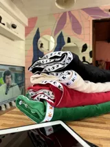 Pantalón de jogging verde de plush con elástico en la cintura, bolsillos y cinta con el logo a lo largo de la pierna.