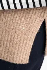 Chaleco de punto color beige con cuello alto y sisas amplias.