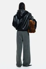 Pantalón de punto con tiro alto y cintura elástica oculta. Presenta un corte de pierna recta con pliegues frontales y un estampado de espiga en tonos grises.