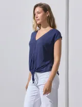 Blusa color beige de modal con escote en V, abertura central con botones y ruedo anudado. Marca French Laundry.