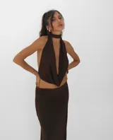 Top de cuello halter con escote profundo y diseño cruzado en el frente, dejando la espalda descubierta. Presenta un ajuste tipo gargantilla integrado al diseño.