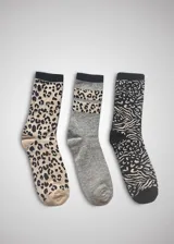 Pack de tres pares de medias de media caña con diseños de animal print: un par con estampado de leopardo en tonos beige y negro, un par gris con una banda de estampado de leopardo y un par negro con estampado de cebra y leopardo.