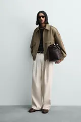 Cazadora de corte cropped fit, color verde oliva, confeccionada en mezcla de viscosa y algodón. Presenta cuello subido, manga larga, trabillas en los hombros, bolsillos de plastrón con solapa en la cadera y cierre frontal con cremallera.