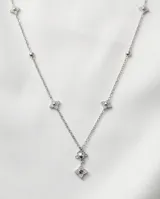 Collar de acero inoxidable con cadena fina y dijes en forma de estrella de cuatro puntas incrustados con circonias.