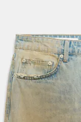 Bermuda de denim de tiro medio y corte baggy, con diseño de cinco bolsillos, trabillas para cinto y rotos decorativos.